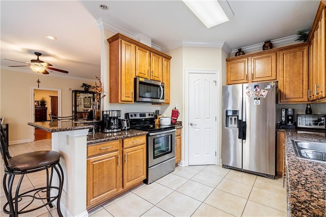1326 Prentiss Ave, New Orleans, LA 70122 - kitchen with appliances with stainless steel finishes, a breakfast bar, brown cabinetry, ornamental molding, and light tile patterned floors