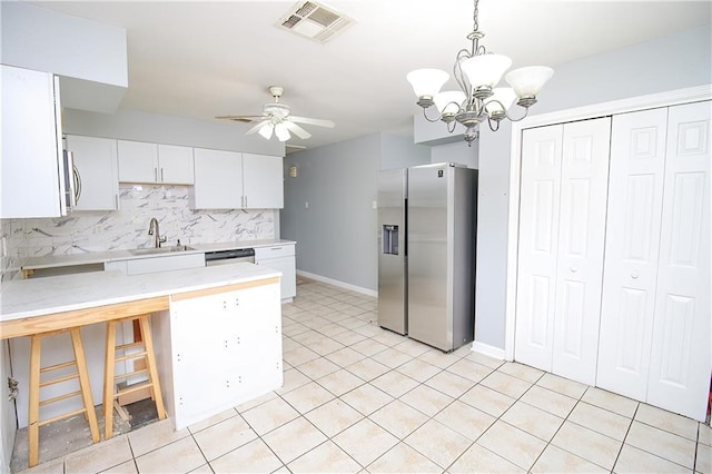 2804 Transcontinental Dr, Metairie, LA 70006 - kitchen featuring appliances with stainless steel finishes, a sink, a peninsula, decorative backsplash, and white cabinetry