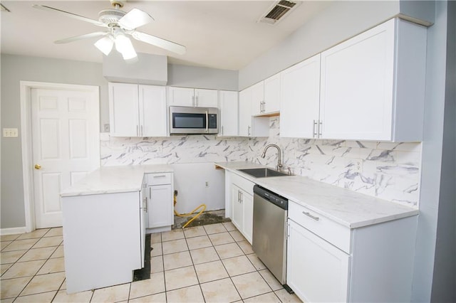 2804 Transcontinental Dr, Metairie, LA 70006 - kitchen with stainless steel appliances, a sink, a ceiling fan, and white cabinets