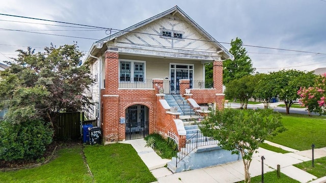 606 Filmore St, New Orleans, LA 70124 - view of front of home with stairs, a porch, brick siding, and a gate