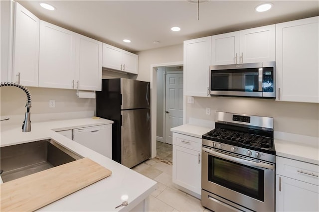 1801 River Oaks Dr, New Orleans, LA 70131 - kitchen featuring appliances with stainless steel finishes, a sink, light countertops, white cabinetry, and recessed lighting