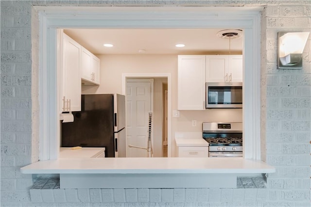 1801 River Oaks Dr, New Orleans, LA 70131 - kitchen featuring appliances with stainless steel finishes, white cabinets, light countertops, and a peninsula