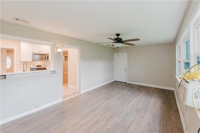 1801 River Oaks Dr, New Orleans, LA 70131 - unfurnished living room featuring light wood finished floors, ceiling fan, baseboards, and a sink