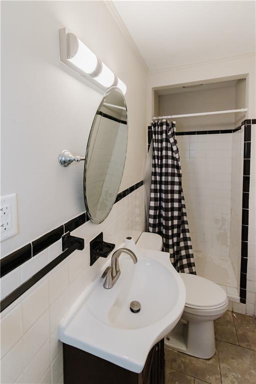 1801 River Oaks Dr, New Orleans, LA 70131 - bathroom with tile walls, a shower stall, toilet, vanity, and tile patterned flooring