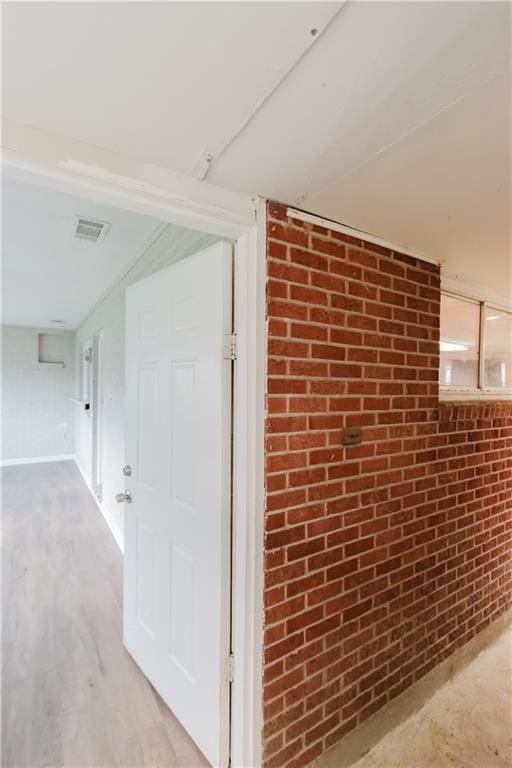 1801 River Oaks Dr, New Orleans, LA 70131 - corridor featuring brick wall and light wood-style floors