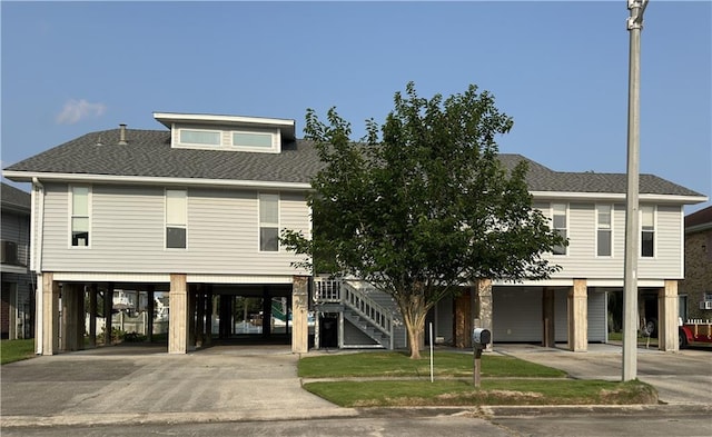 4231 San Trovaso St, New Orleans, LA 70129 - view of front of house with a carport, driveway, and a shingled roof