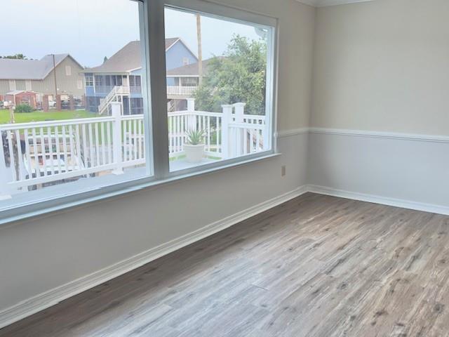4231 San Trovaso St, New Orleans, LA 70129 - empty room featuring wood finished floors and a residential view