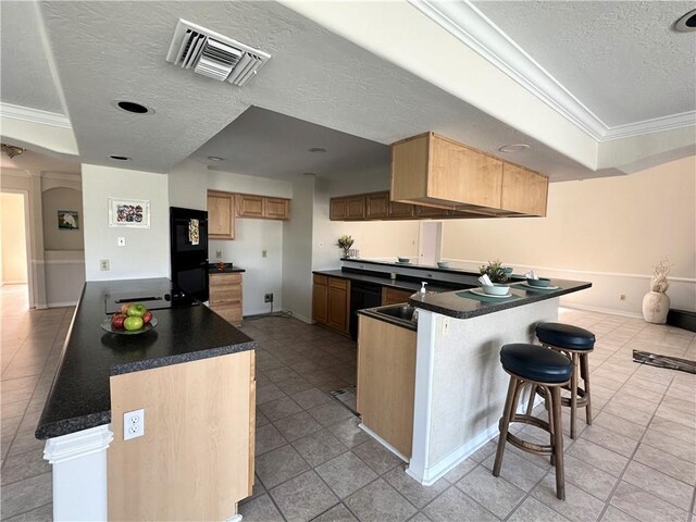 4231 San Trovaso St, New Orleans, LA 70129 - kitchen featuring a textured ceiling, a peninsula, ornamental molding, a breakfast bar, and dark countertops