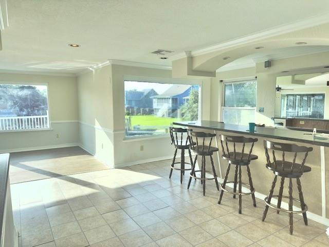 4231 San Trovaso St, New Orleans, LA 70129 - dining space with ornamental molding, light tile patterned flooring, and arched walkways