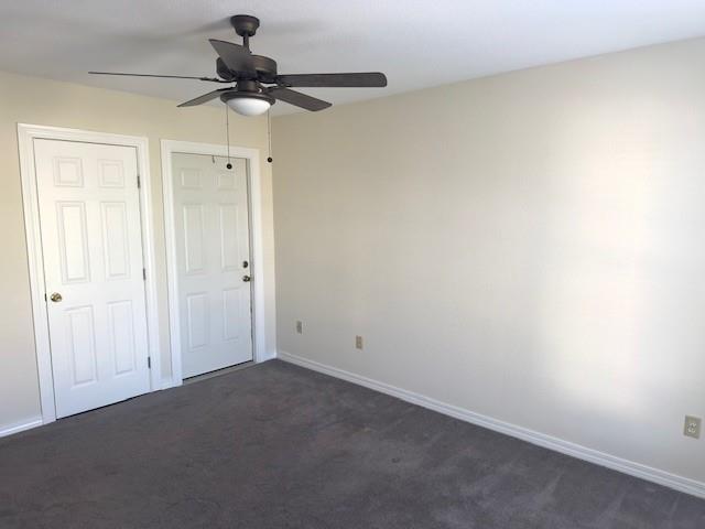 4231 San Trovaso St, New Orleans, LA 70129 - unfurnished bedroom with dark carpet and ceiling fan