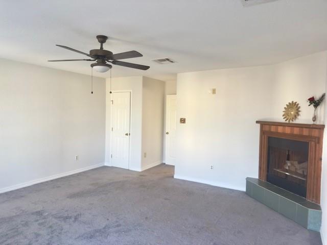 4231 San Trovaso St, New Orleans, LA 70129 - unfurnished living room with a fireplace with raised hearth, a ceiling fan, and carpet flooring