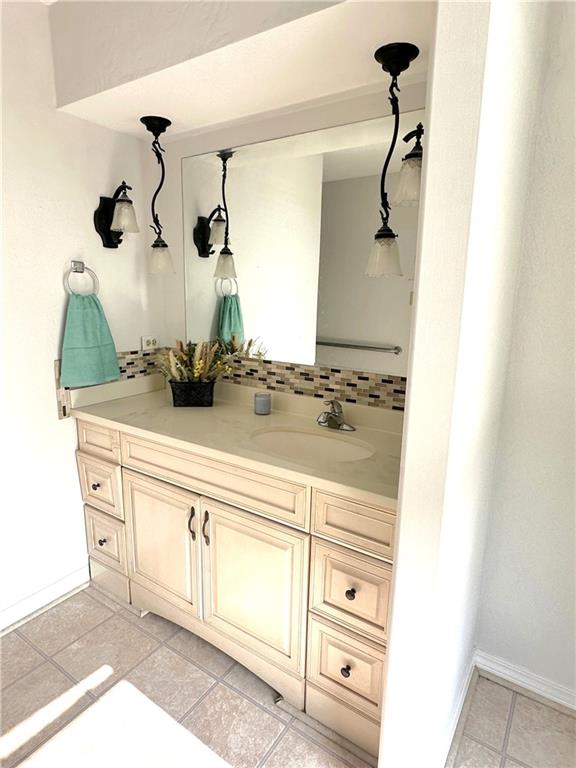 4231 San Trovaso St, New Orleans, LA 70129 - bathroom featuring vanity, decorative backsplash, and tile patterned flooring
