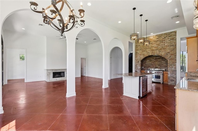 155 Sauve Rd, River Ridge, LA 70123 - kitchen with a fireplace, wine cooler, high end stainless steel range oven, a chandelier, and dark tile patterned floors
