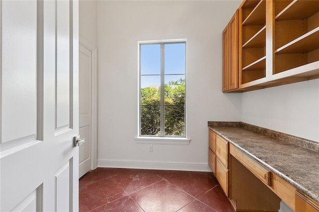 155 Sauve Rd, River Ridge, LA 70123 - unfurnished office with built in desk, baseboards, and dark tile patterned floors