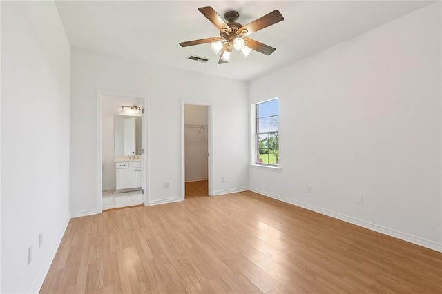 155 Sauve Rd, River Ridge, LA 70123 - unfurnished bedroom featuring a walk in closet, light wood-style floors, baseboards, a closet, and ensuite bathroom
