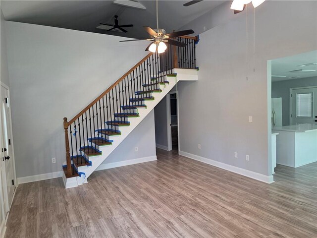 59478 S Tranquility Rd, Lacombe, LA 70445 - unfurnished living room with ceiling fan, stairway, a towering ceiling, baseboards, and wood finished floors