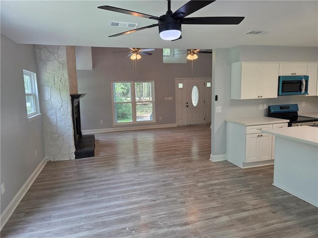59478 S Tranquility Rd, Lacombe, LA 70445 - kitchen featuring appliances with stainless steel finishes, ceiling fan, white cabinetry, light wood-style floors, and light countertops