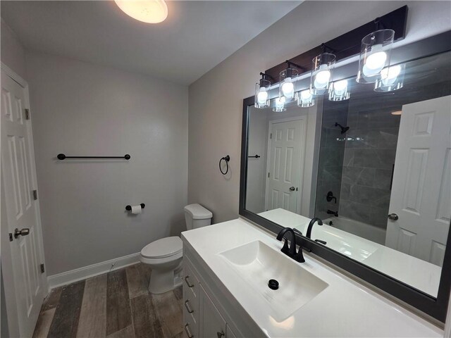 59478 S Tranquility Rd, Lacombe, LA 70445 - bathroom with wood finished floors, toilet, vanity, baseboards, and  shower combination