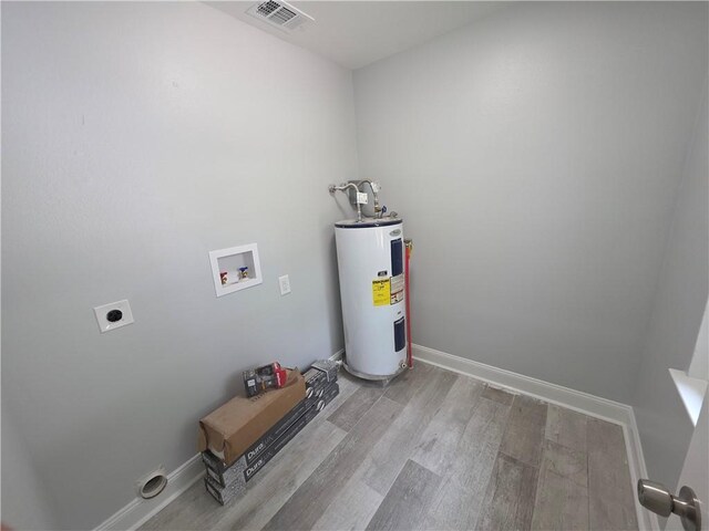 59478 S Tranquility Rd, Lacombe, LA 70445 - laundry area with water heater, hookup for an electric dryer, washer hookup, light wood-type flooring, and baseboards