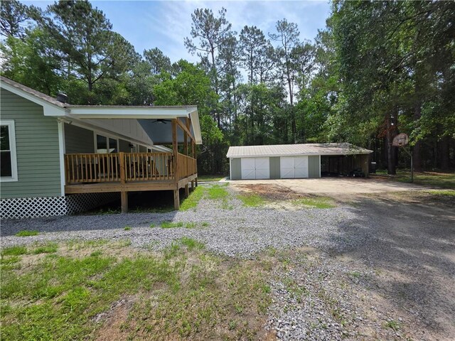 59478 S Tranquility Rd, Lacombe, LA 70445 - view of side of home with an outdoor structure, a detached garage, and view of wooded area