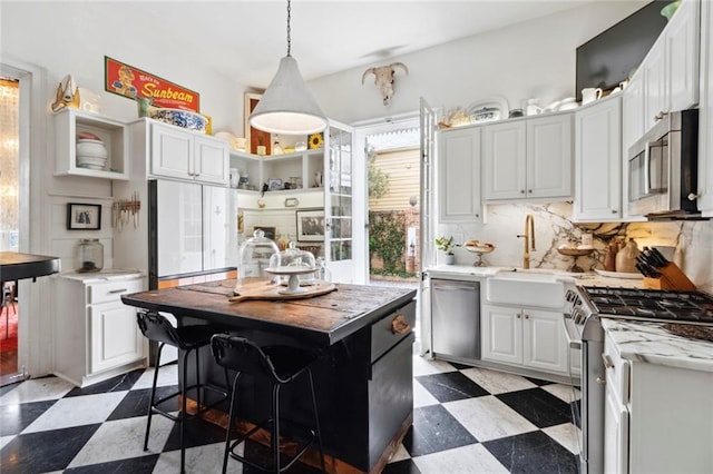 927 Dauphine St, New Orleans, LA 70116 - kitchen featuring appliances with stainless steel finishes, light floors, open shelves, and a sink