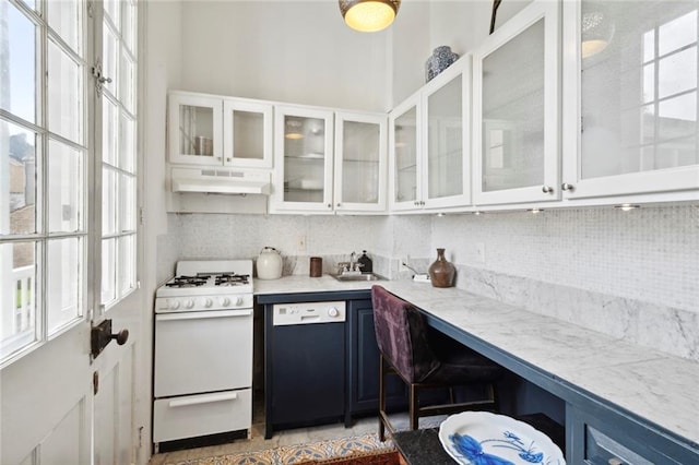 927 Dauphine St, New Orleans, LA 70116 - kitchen with white gas range, dishwashing machine, under cabinet range hood, and decorative backsplash