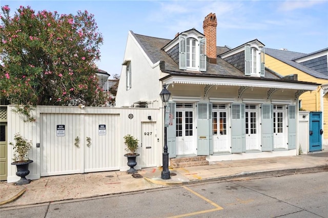 927 Dauphine St, New Orleans, LA 70116 - back of house with a chimney, roof with shingles, and a gate