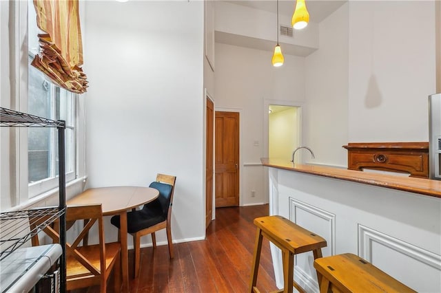 820 St Ann St Unit A, New Orleans, LA 70116 - dining space with dark wood-type flooring, a towering ceiling, and baseboards