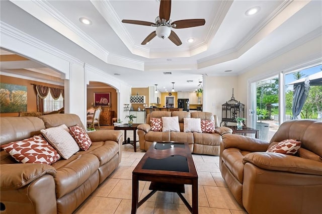 581 S Military Rd, Slidell, LA 70461 - living room with a ceiling fan, arched walkways, ornamental molding, a tray ceiling, and light tile patterned floors