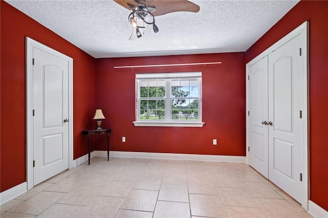 581 S Military Rd, Slidell, LA 70461 - unfurnished bedroom featuring a textured ceiling, a ceiling fan, baseboards, and light tile patterned floors