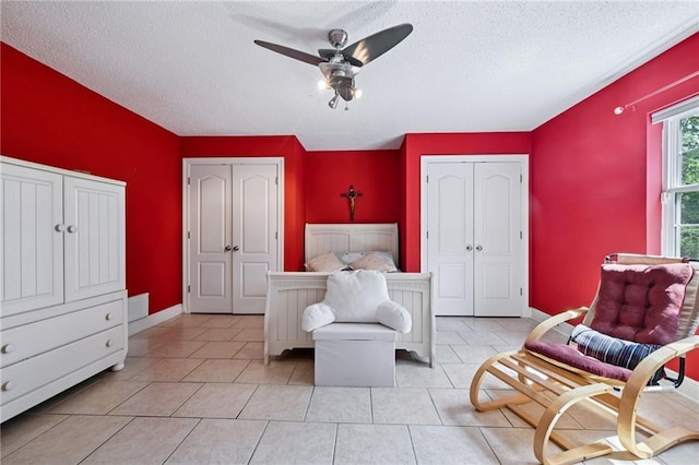 581 S Military Rd, Slidell, LA 70461 - bedroom featuring two closets, a textured ceiling, a ceiling fan, and baseboards