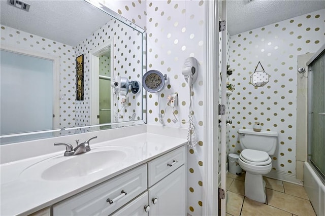 581 S Military Rd, Slidell, LA 70461 - bathroom with a textured ceiling, wallpapered walls, vanity, toilet, and tile patterned flooring