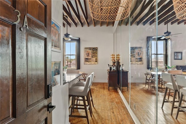 4716 Annunciation St Unit 3A, New Orleans, LA 70115 - dining area featuring a ceiling fan, light wood-type flooring, beam ceiling, and a towering ceiling
