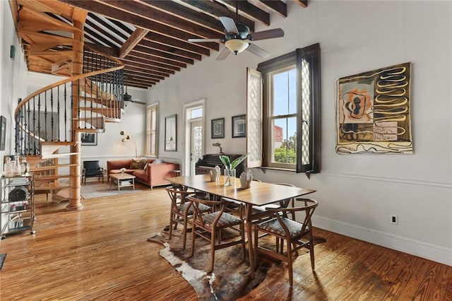 4716 Annunciation St Unit 3A, New Orleans, LA 70115 - dining room featuring stairway, beamed ceiling, a ceiling fan, wood finished floors, and a towering ceiling