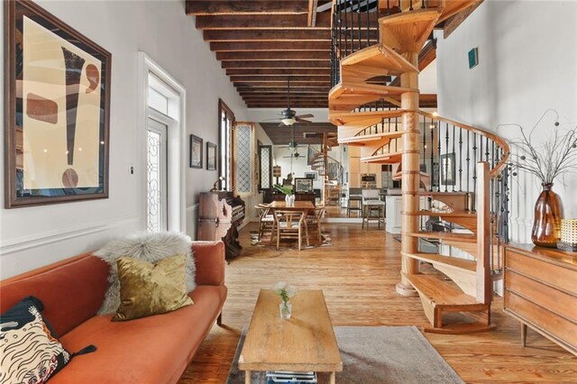 4716 Annunciation St Unit 3A, New Orleans, LA 70115 - living area with stairs, wood finished floors, ceiling fan, beam ceiling, and a high ceiling