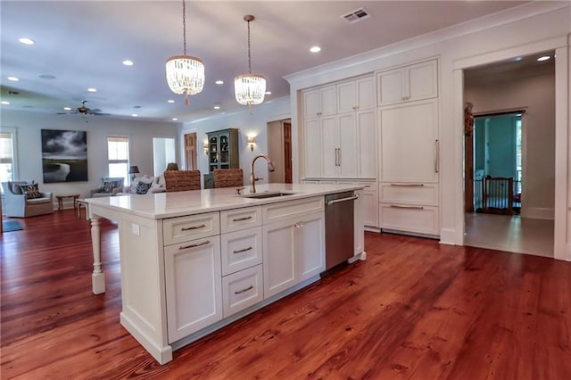 607 E 3rd Ave, Covington, LA 70433 - kitchen featuring stainless steel dishwasher, a sink, a chandelier, a center island with sink, and hanging light fixtures