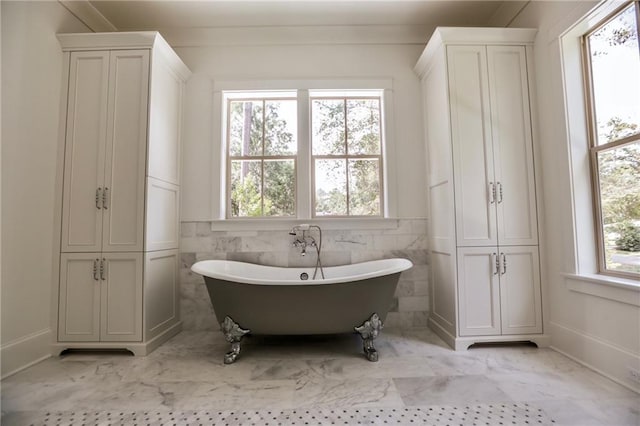 607 E 3rd Ave, Covington, LA 70433 - full bathroom with a closet, a soaking tub, marble look tile flooring, and baseboards