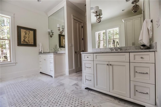 607 E 3rd Ave, Covington, LA 70433 - bathroom featuring marble finish flooring, two vanities, baseboards, and ornamental molding