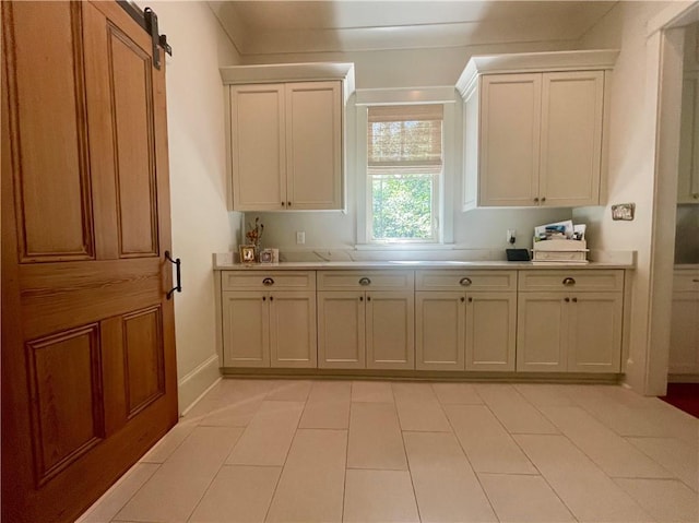 607 E 3rd Ave, Covington, LA 70433 - kitchen featuring light countertops, a barn door, and baseboards