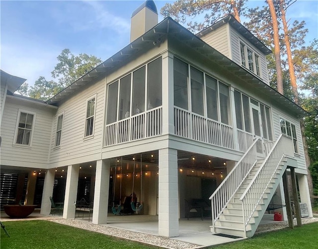 607 E 3rd Ave, Covington, LA 70433 - rear view of house featuring a sunroom, a patio, and a chimney