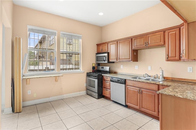 2031 General Taylor St, New Orleans, LA 70115 - kitchen featuring appliances with stainless steel finishes, a sink, light tile patterned floors, baseboards, and recessed lighting