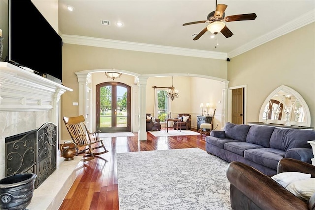 1132 Scarlet Oak Ln, Mandeville, LA 70448 - living area with ornate columns, arched walkways, a high end fireplace, french doors, and wood finished floors