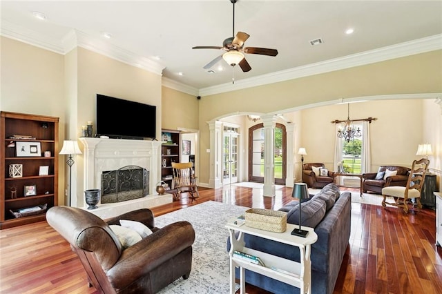 1132 Scarlet Oak Ln, Mandeville, LA 70448 - living room with decorative columns, hardwood / wood-style floors, arched walkways, ceiling fan, and ornamental molding