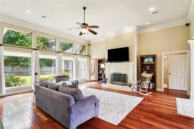 1132 Scarlet Oak Ln, Mandeville, LA 70448 - living area featuring a fireplace with raised hearth, ceiling fan, wood finished floors, ornamental molding, and recessed lighting