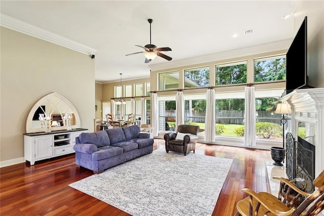 1132 Scarlet Oak Ln, Mandeville, LA 70448 - living area with ornamental molding, a ceiling fan, a premium fireplace, wood finished floors, and baseboards