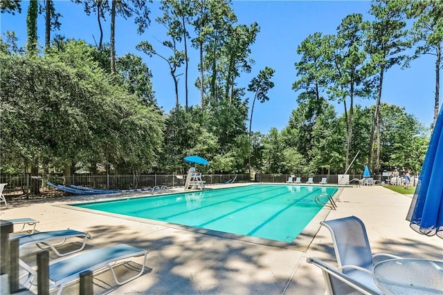 1132 Scarlet Oak Ln, Mandeville, LA 70448 - community pool with a patio and view of wooded area