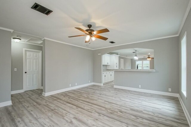 70 Old Hickory St, Chalmette, LA 70043 - unfurnished living room with a ceiling fan, light wood-type flooring, arched walkways, baseboards, and crown molding