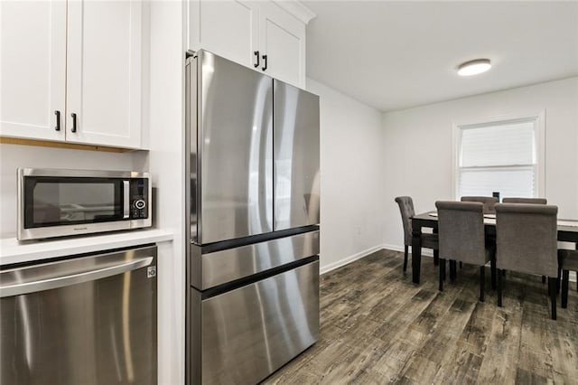 6200 Leslie St, Metairie, LA 70003 - kitchen featuring appliances with stainless steel finishes, dark wood-style flooring, white cabinetry, and baseboards
