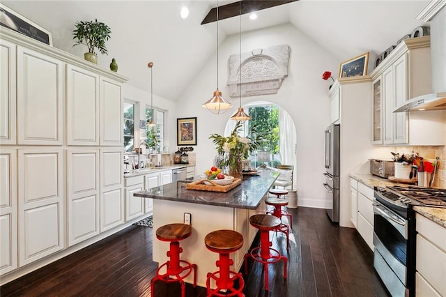 6838 Catina St, New Orleans, LA 70124 - kitchen featuring stainless steel appliances, a center island, wall chimney exhaust hood, high vaulted ceiling, and dark wood-style floors