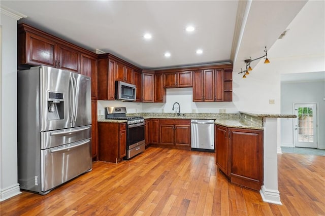 4232 Cadiz St, New Orleans, LA 70125 - kitchen featuring stainless steel appliances, a peninsula, light wood-style floors, light stone counters, and recessed lighting